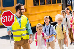 在校车前与小学生一起过马路的英俊交通保安