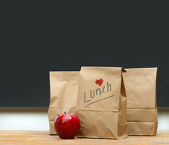 午餐袋与学校桌子上的苹果