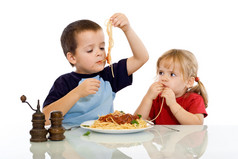 两个孩子吃意大利面用他们的双手