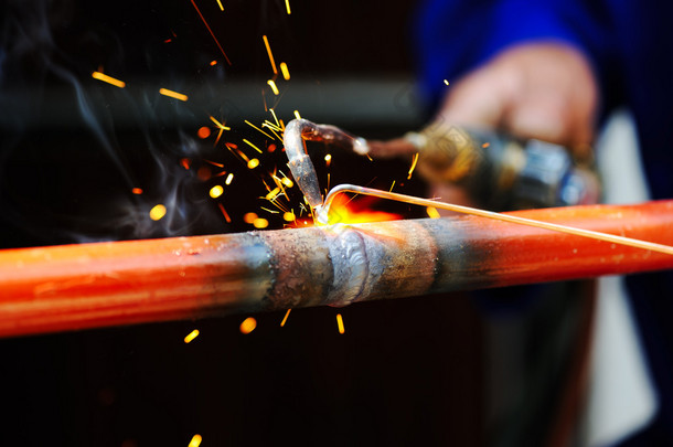 焊工在金属物体上使用火炬