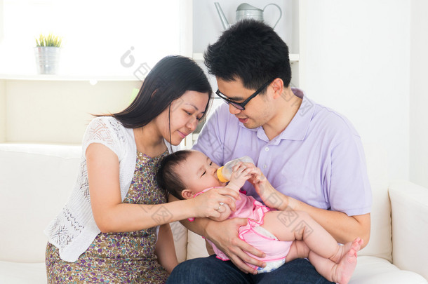 亚洲父母喂养婴儿男孩在家里