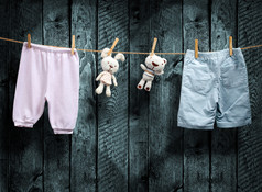 婴儿的衣服和一只泰迪熊在晾衣绳上