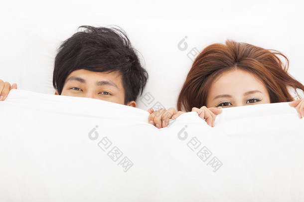 躺在床上对年轻快乐夫妇