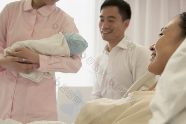 护士抱着刚出生的婴儿的母亲