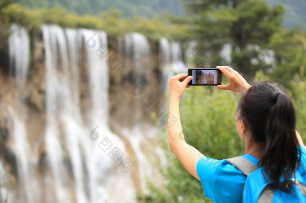 随着智能手机的女人旅游拍照