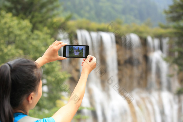 随着智能手机的女人旅游拍照