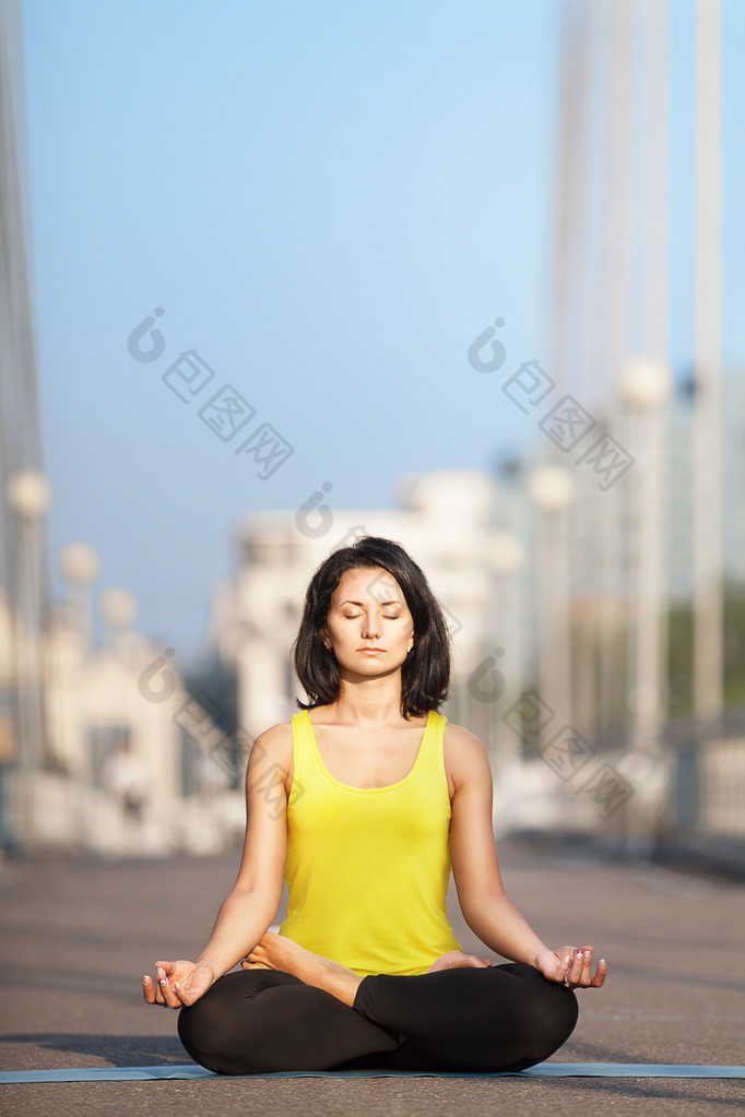 美丽的女人做瑜伽背景下的城市 landsc