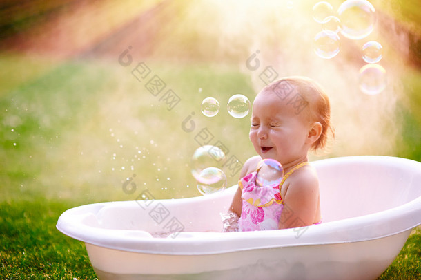 漂亮的小女孩，在夏天洗澡用肥皂泡