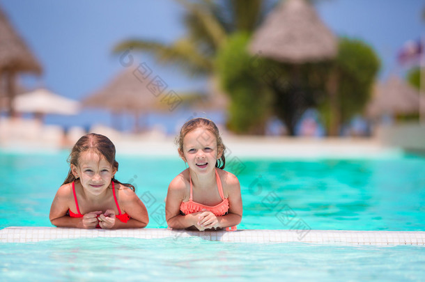 可爱的小女孩在室外游<strong>泳池里玩耍</strong>