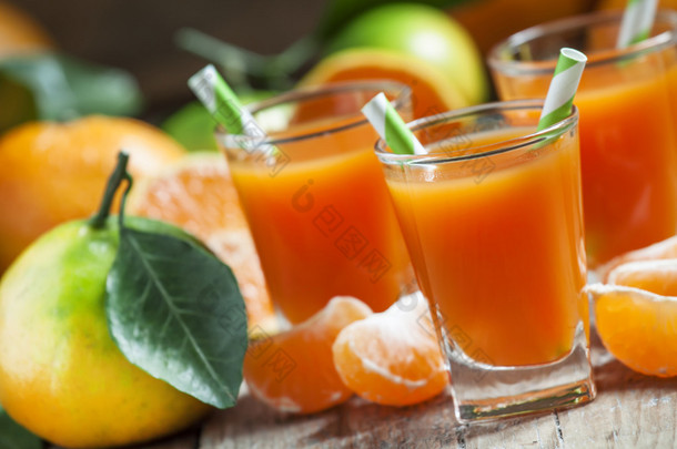 用带条纹<strong>的</strong>吸管装在一个小杯里<strong>的</strong>新鲜成熟柑橘汁