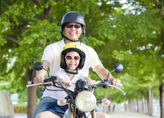 快乐的父亲和女儿在摩托车上行驶 