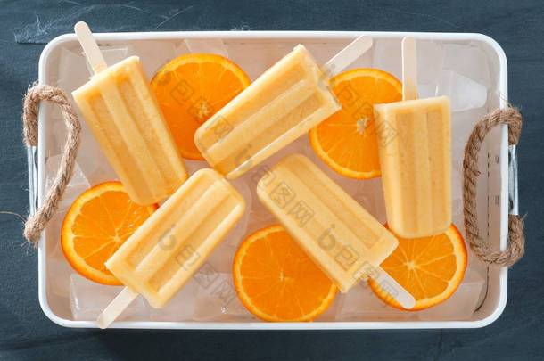在乡村的橙色酸奶冰棍冰填充的托盘