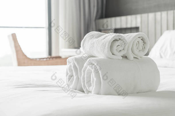 在卧室内床上装饰上的白毛巾 
