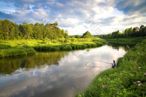 在炎热的夏天在乡下河上钓鱼.