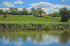 乡村景观的照片。绿色的山、 蓝色的湖和多云的天空，在炎热的夏天