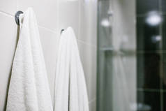 白毛巾挂在浴室的墙上。清洁、 淋浴.
