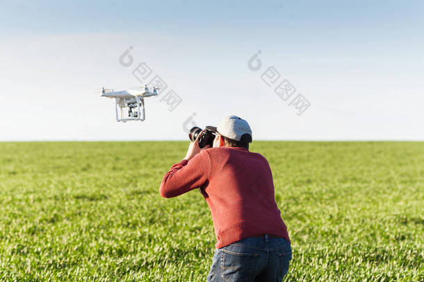 quadcopter 夏季户外、 航拍图像和娱乐概念 — — 会议的低空飞行的无人驾驶飞机和夏天场的绿色小麦，蓝色天空背景下，相互摄影专业摄影师.