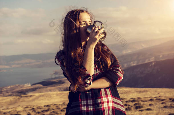 一个女孩在喝一大杯，四面环山的格子衬衫