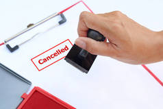 用红色墨水垫 (盒) 对白色背景的纸页上的近手冲压取消.