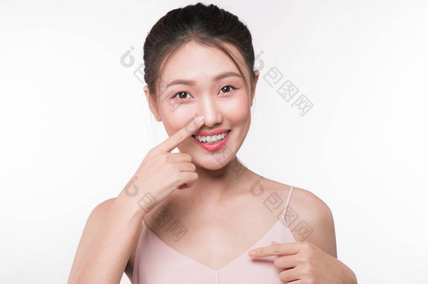 年轻美丽的亚洲妇女与微笑的面孔触碰了她的鼻子.