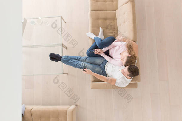 年轻夫妇在沙发上<strong>看电视</strong>顶视图