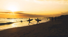 美丽的海景在黄昏与冲浪者的剪影。在热带沙滩上的日落。冲浪者在热带国家度过夏天的假期, 有好的海浪.