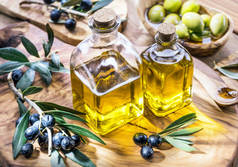 橄榄油和浆果在橄榄木托盘上. 