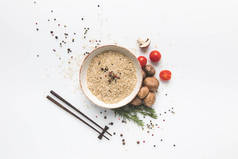 用筷子在白色表面用蘑菇和西红柿在碗中生米的平的放置成分