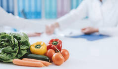 在办公室工作的专业营养学家和健康的新鲜蔬菜的前景: 饮食和健康概念