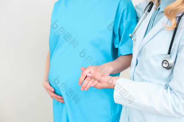 妇产科妇科医生帮助孕妇走路和握住她的手的裁剪镜头