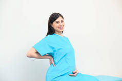 快乐的年轻孕妇坐在产科医院的床上