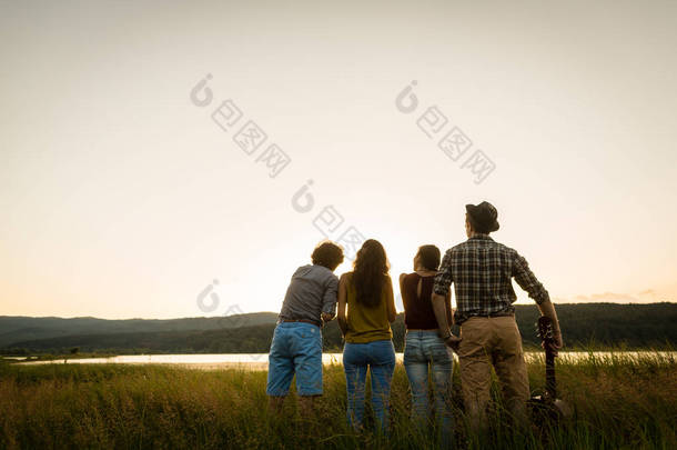 一群朋友在黄昏的夏日望着地平线