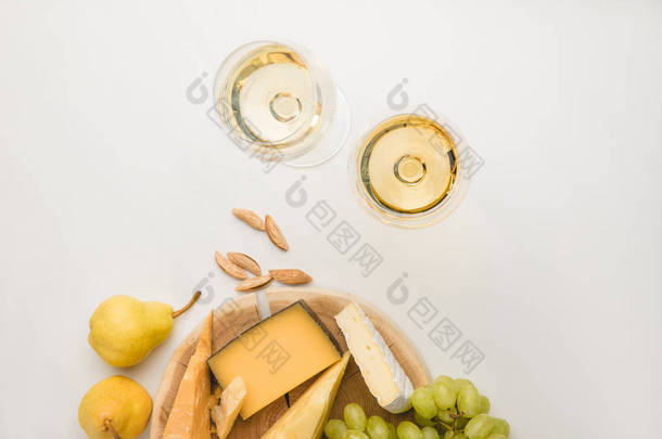在木板, 酒杯, 杏仁和水果的白色的不同类型的奶酪的顶级视图
