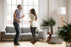 年轻快乐的情侣在客厅里一起跳舞快乐