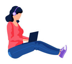 带耳机的女孩坐在电脑前。女自由职业者在笔记本电脑上工作或学习