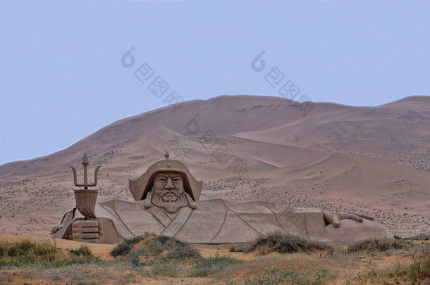 位于巴丹东湖对面的高大沙丘中，<strong>成吉思汗</strong>的巨大硬砂雕塑。Badain Jaran-Badanjilin Shamo-Mysterious Lakes Desert-section of Gobi Des