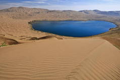 全景努尔图湖- -巴丹贾兰沙漠中最大的湖，有1 '45 km2-和东部的大型湖泊，从420 m.high of its Western megadune在朦胧稀少的蓝天下俯瞰。内蒙古-中国