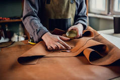在他的硕士班里，一位经验丰富的制革师展示了如何使用皮革，并把它摆在桌上
