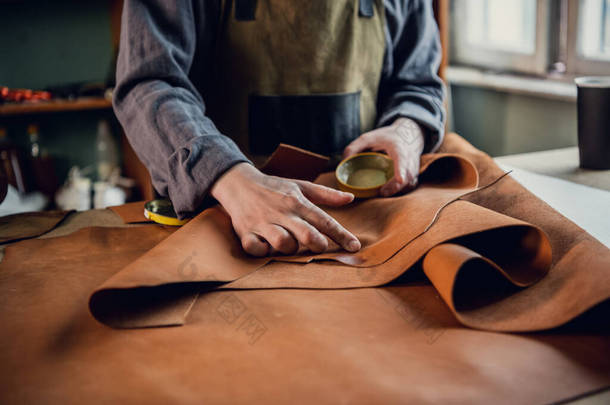 在他的硕士班里，一位经验丰富的制革师展示了如何使用皮革，并把它摆在桌上