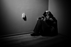伤心女人独自坐在一个空的房间-黑色和白色