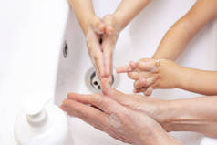 成年人和儿童洗手。用抗菌肥皂中的泡沫手拉手。对细菌的保护，考拉威斯。手卫生。用水洗手。很多人