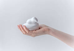 手拿着白色泡沫，发泡，男用泡沫，白色纹理，手拿着用白色背景隔开的肥皂
