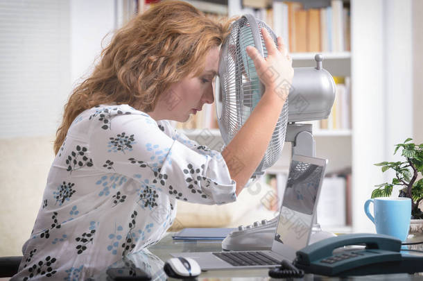 3.女人在办公室里工作时感到很热，所以尽量靠著风扇凉快一点