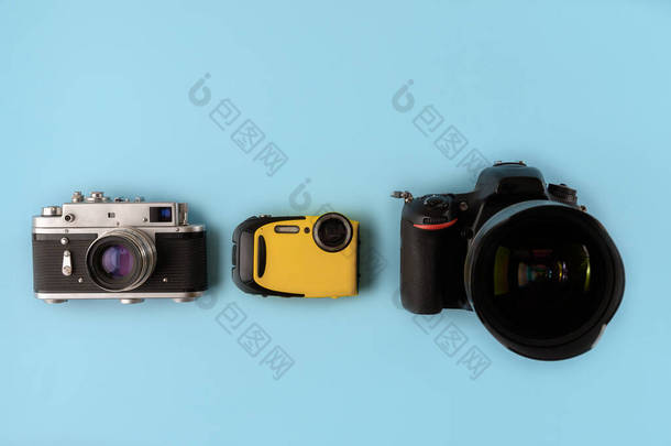 相机的演变。不同类型和世代的相机在蓝色背景上，顶部视图，平面布局。三台蓝色背景的不同世代的摄像机照相机的技术进步