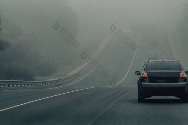 大雾中的汽车在危险的天气行驶在高速公路上.能见度低，道路上的汽车交通状况<strong>差</strong>。高速公路上迷雾中的车辆