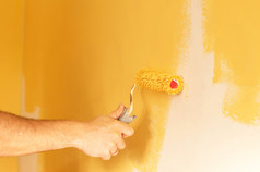在黄色的颜色粉刷墙壁的过程 