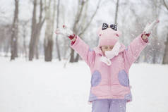 快乐的爱着母亲和女儿的高加索家庭玩耍，在冬天的雪地公园里玩得很开心。 可爱的小女孩在玩耍