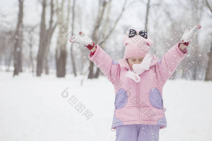 快乐的爱着母亲和女儿的高加索家庭玩耍，在冬天的雪地公园里玩得很开心。 可爱的小女孩在玩耍