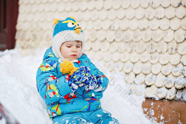 可爱的学龄前小男孩穿着五颜六色的冬衣，在雪地里玩着雪和雪花。冬天和孩子们一起积极地在户外休闲.快乐的孩子在家里的楼梯上<strong>滑行</strong>