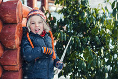 快乐的小学生在户外玩雪。冬天散步时, 孩子穿着暖和的衣服。冬季多雪的天气。快乐的童年。寒假。小男孩在冬天降雪的时候玩得很开心